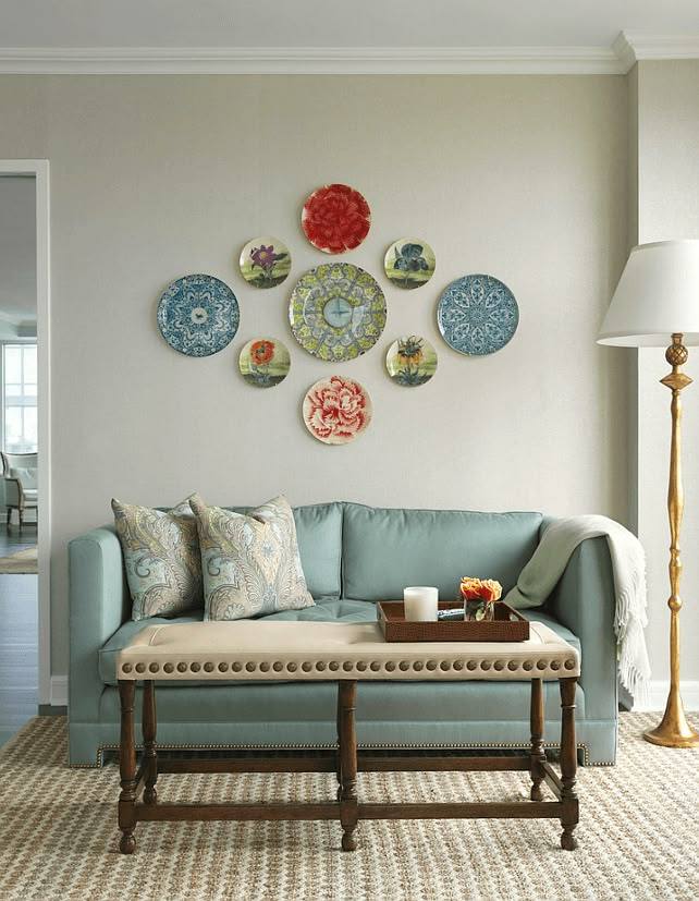 Floral ceramic plates as art on wall and a blue sofa 