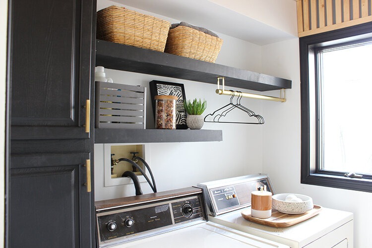 Black floating shelves on white wall with jute basket and other items 