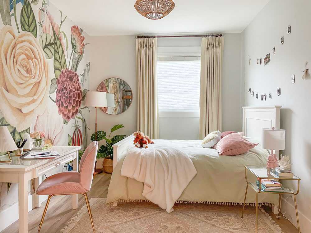 Pink floral wallpaper and a table with pink chair and a bed