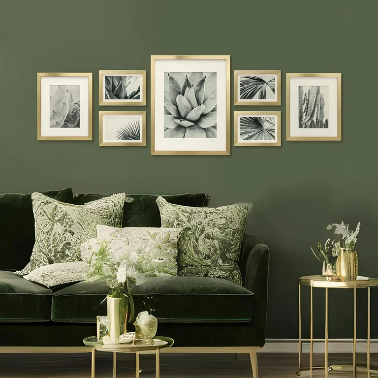 Golden frame art painting on green wall and a green sofa and golden table