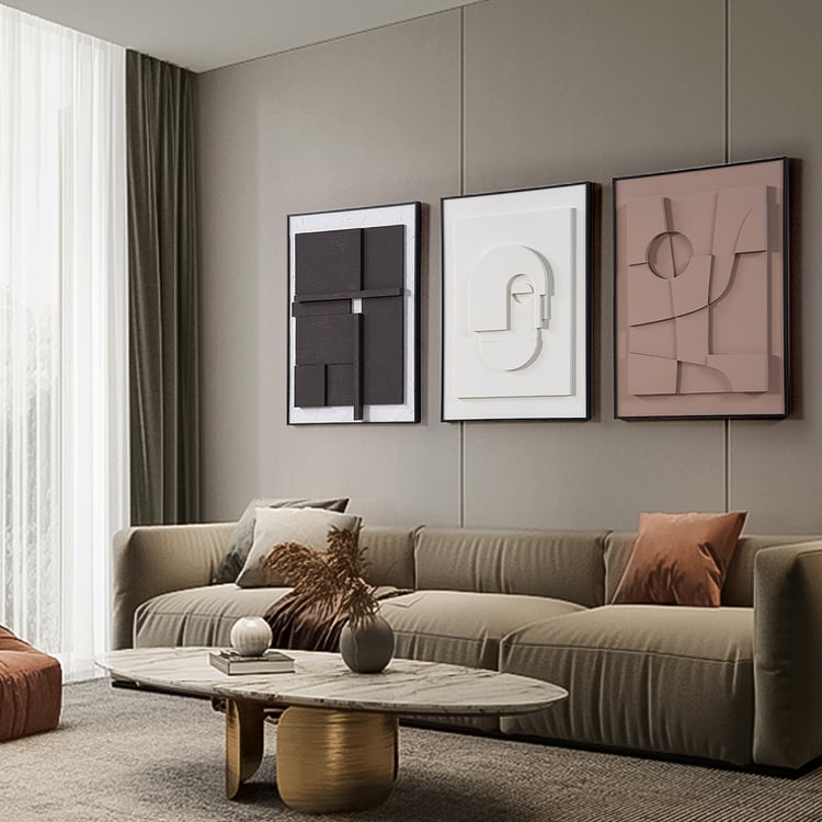 Gray color wall panelling and three art frames on them and a grey color sofa with a marble table