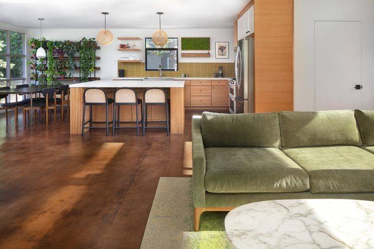 Green sofa and wooden flooring plus wooden kitchen cabinets