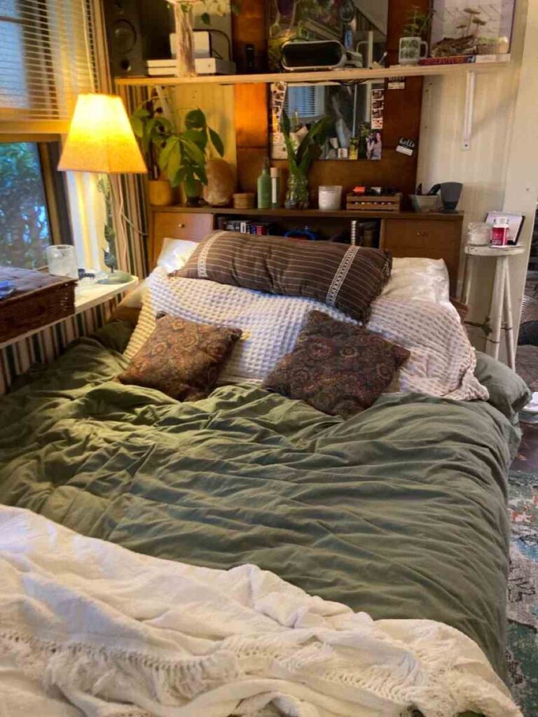 Green, white and brown bed duvet set with a side lamp and a floating shelve above it