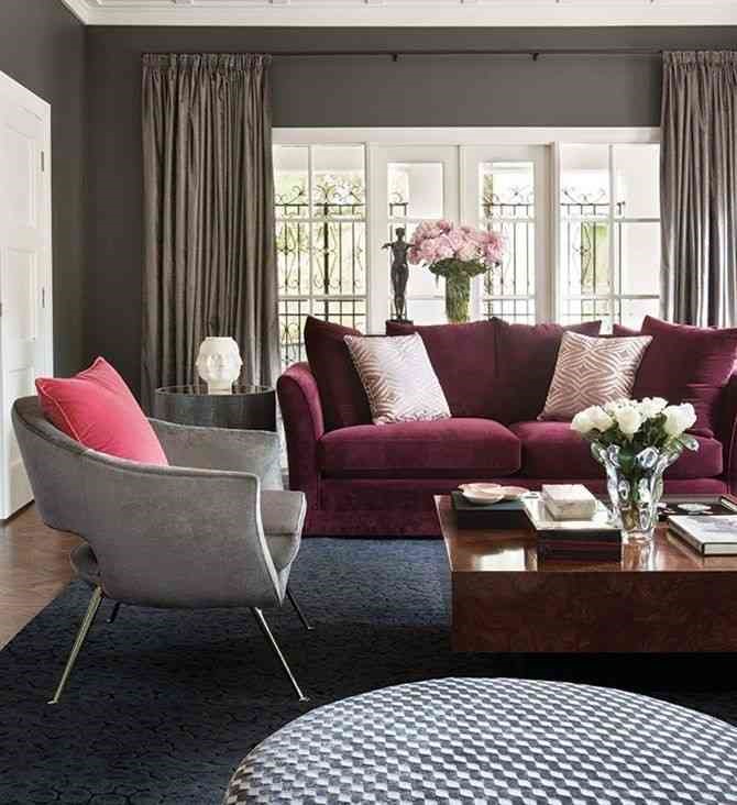 Gray color armchair and a burgundy sofa against the gray wall