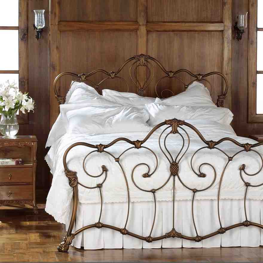 Wooden wall panelling and a brass colored iron made bed frame