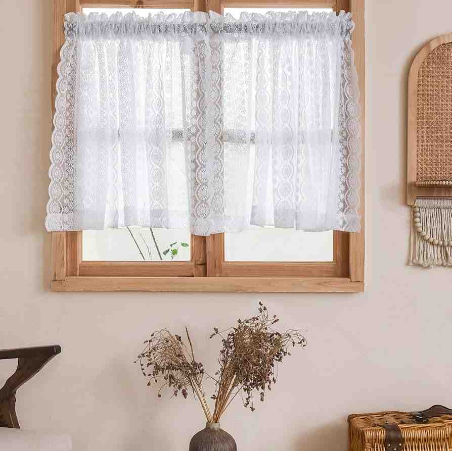 Lace white cafe curtains on wooden window and cream wall