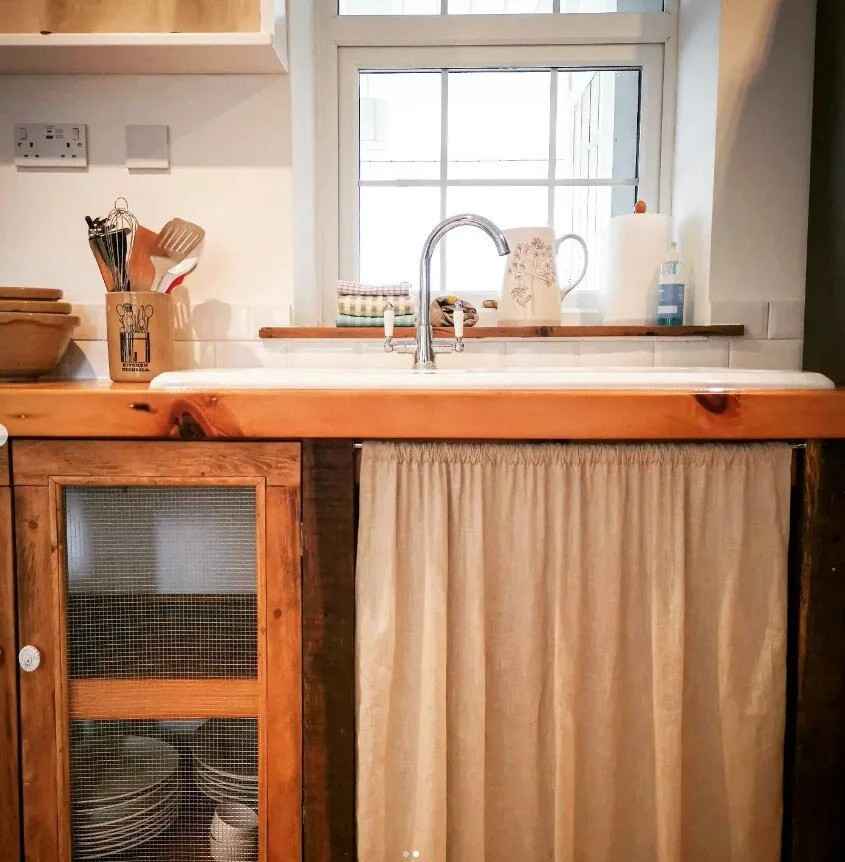 Light orange curtains to cove the space under the sink
