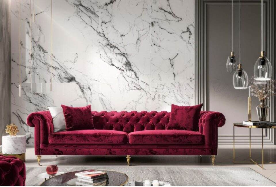 Marble finish wall in grey color and three glass light and a burgundy velvet sofa