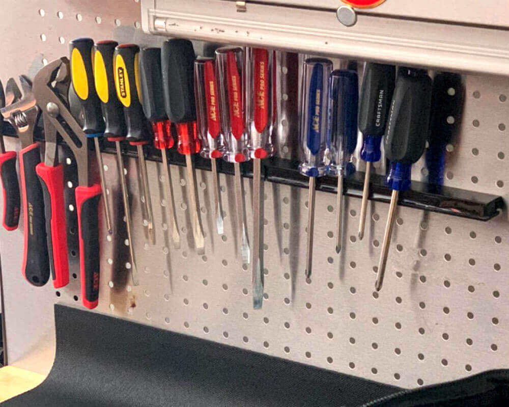 White pegboard and a black magnetic strip for the tools to hang