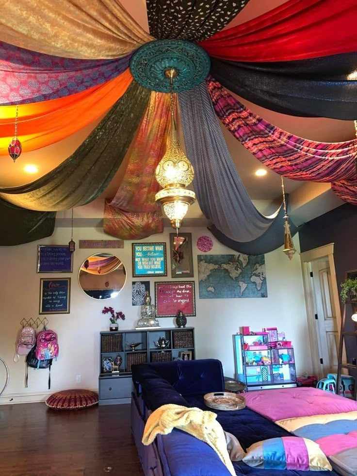 Multiple tapestries as a canopy on ceiling and a ceiling statement lamp and frames on wall