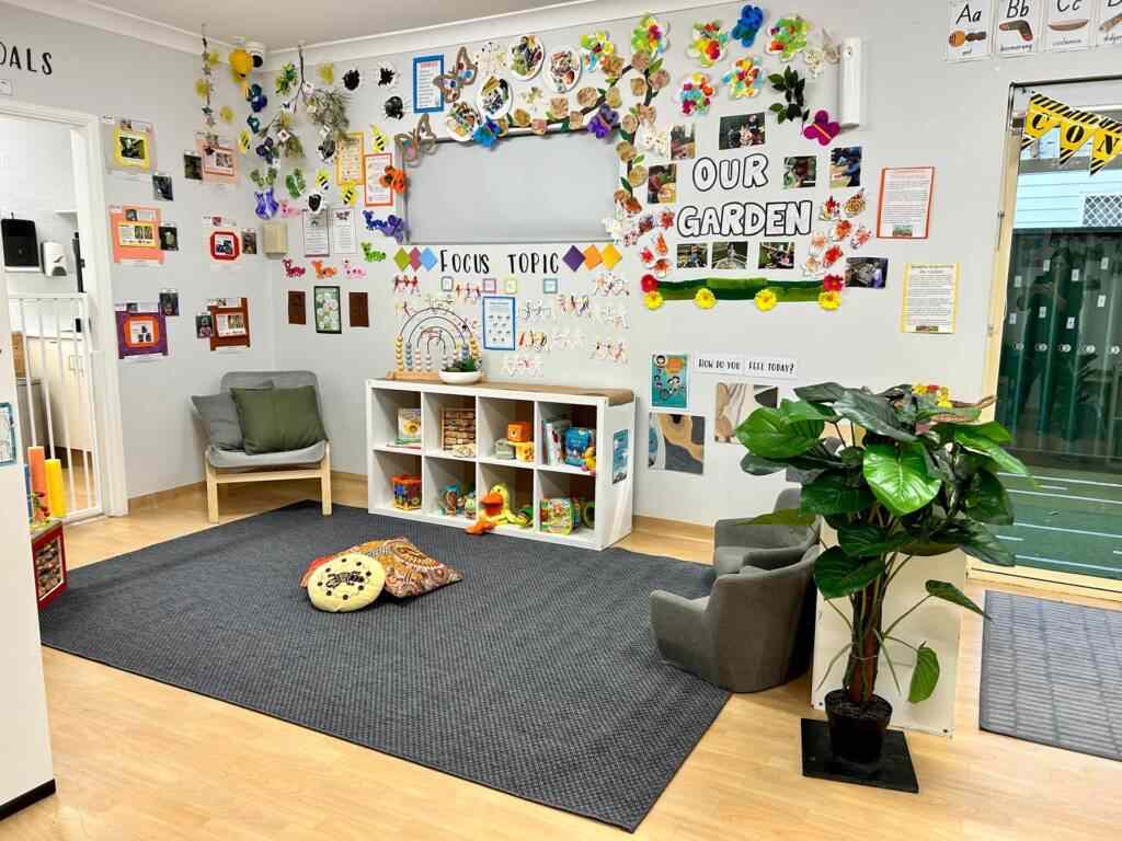 Photos and handmade paper flower on wall and a chair on mat