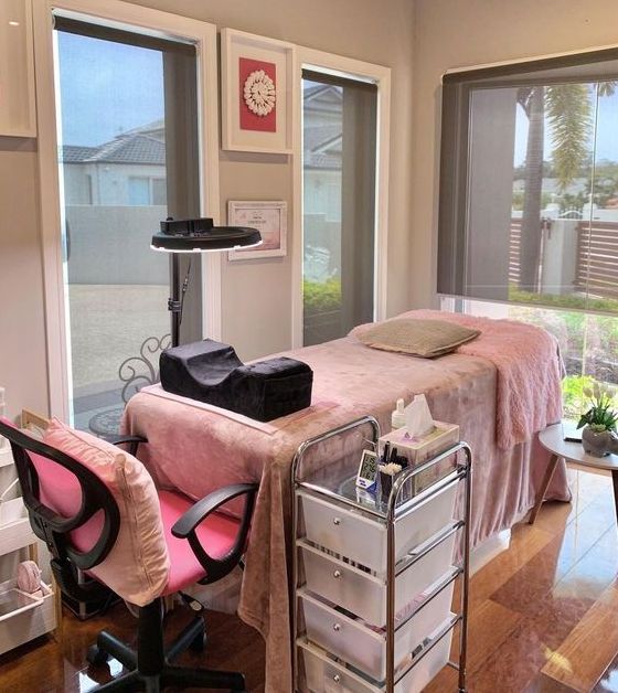 Pink velvet lash bed and a trolley beside it with a chair 