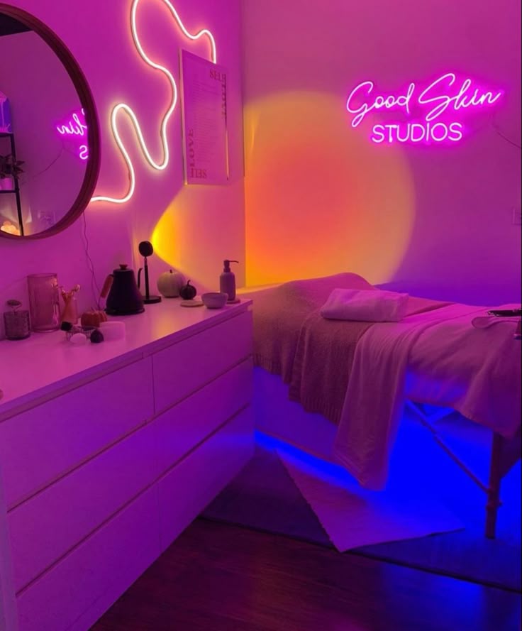Pink and sunset lights in the room with a lash bed and a wooden cabinet