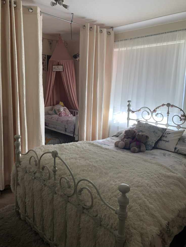 Toddler and baby sharing the same room and a white curtain separating the space in the room