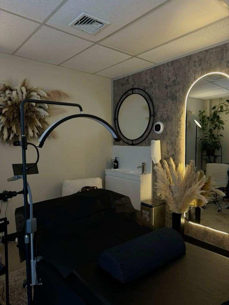 Tow mirror on wall with led light and a black frame in front of the lash bed 