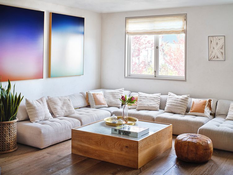 A window above the sofa and two painting in blue and white color