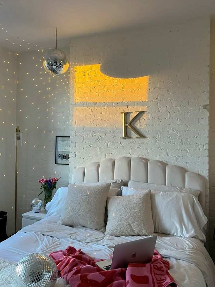 White bed frame and a disco ball hanging from the ceiling