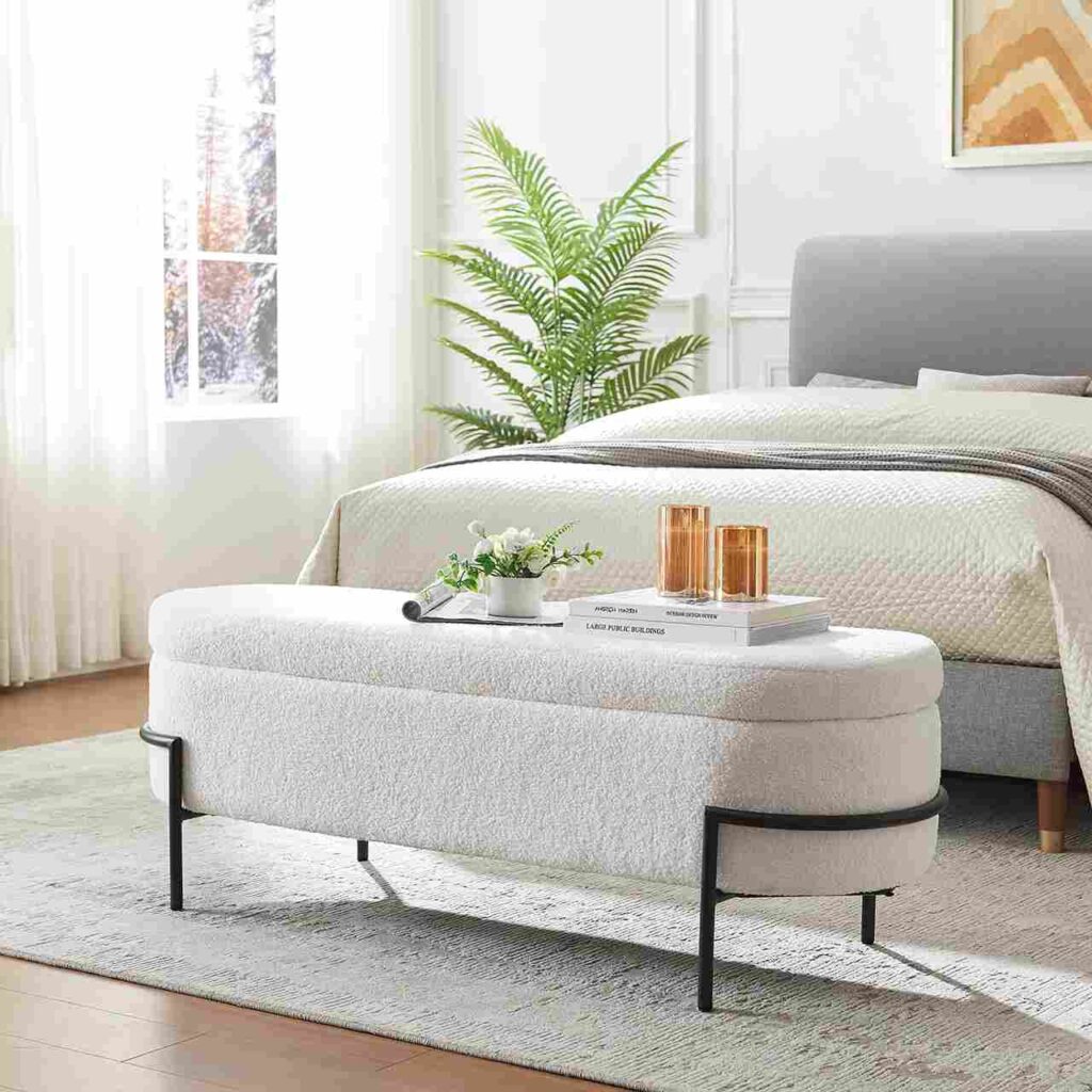 White fur bench and metal black frame leg and a bed with a plant in corner