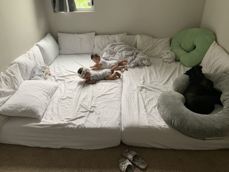 Two babies on white mattress on floor for sleeping