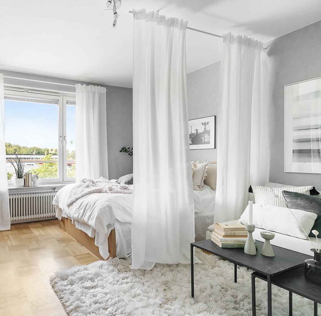 White sheer curtains floor to ceiling length and a black wooden table