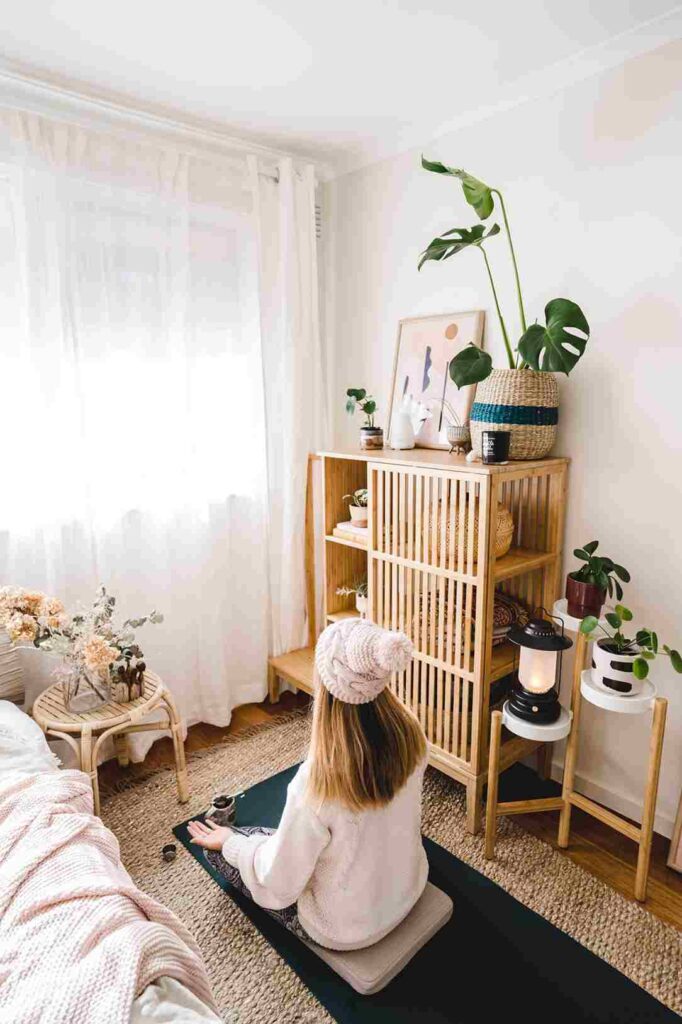 White sheer curtains on window floor length with a wooden cabinet and a girl doing a meditation