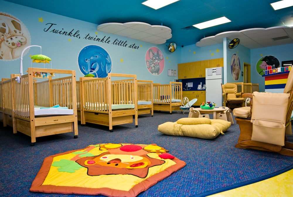 Wooden bed frames and blue wall with a carpet under it and a cartoon rug