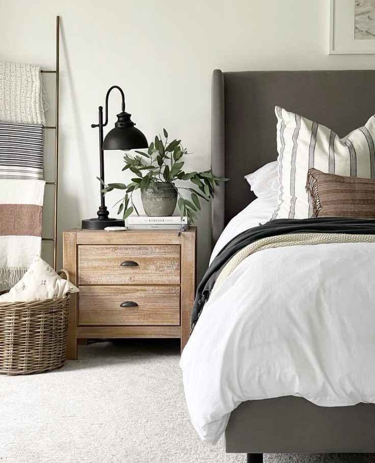 Wooden bedside table and a black lamp on it against white wall