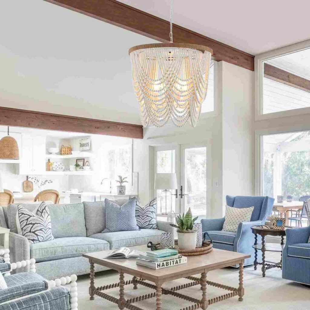 Wooden coffee table and blue color sofa with a beaded chandelier hanging from ceiling