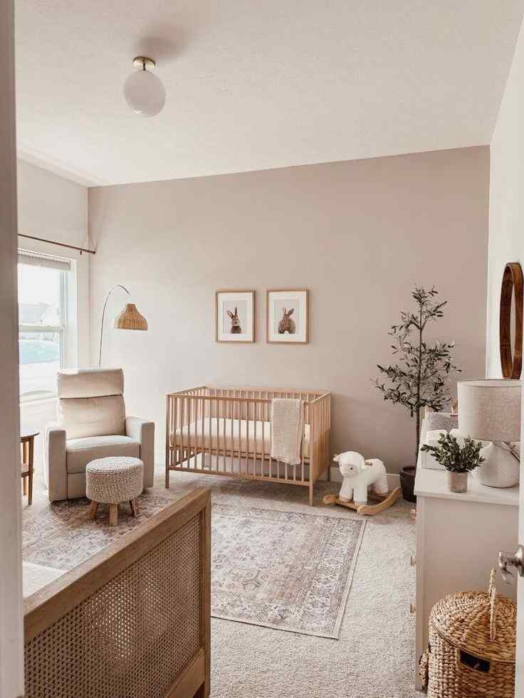 Wooden crib and a cream color armchair and a beige color wall for the baby and toddler room