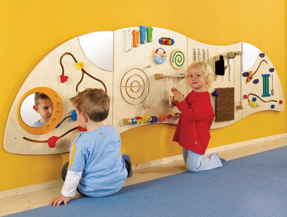 Wooden frame game board on wall and two kids playing on it