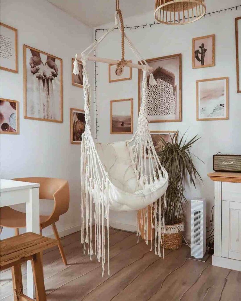 Wooden frames on wall and a white hammock hanging chair and wooden flooring