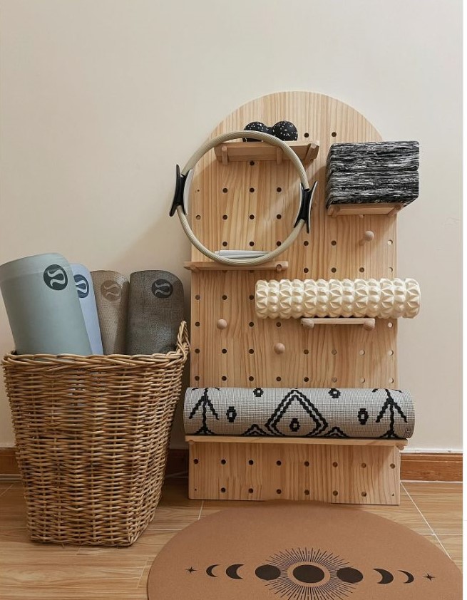 Wooden pegboard and rattan basket in yoga room for the storage