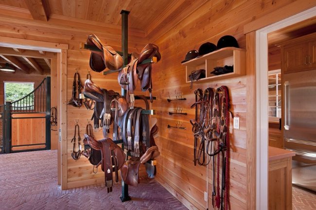 Wooden tack room with brick flooring and a pole to hang items