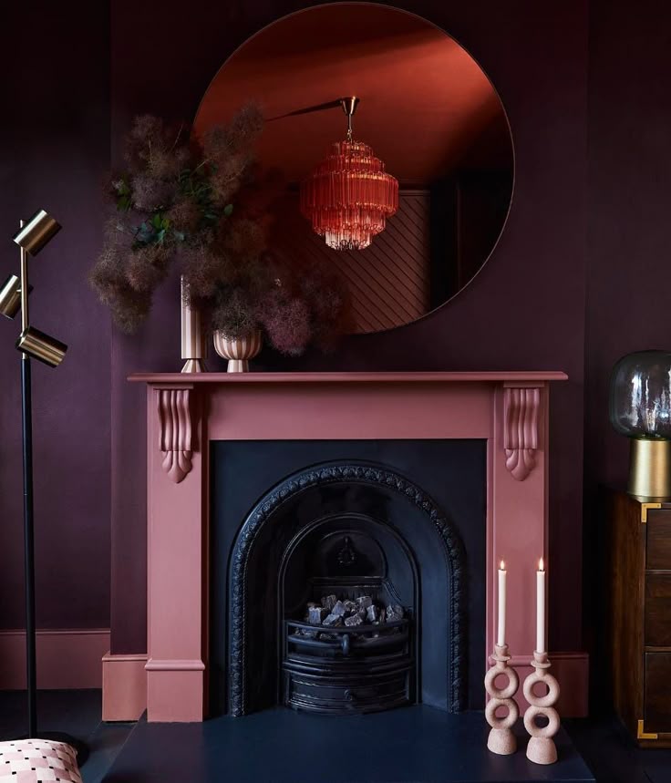 burgundy and black fireplace with a lamp above it and two candle beside it