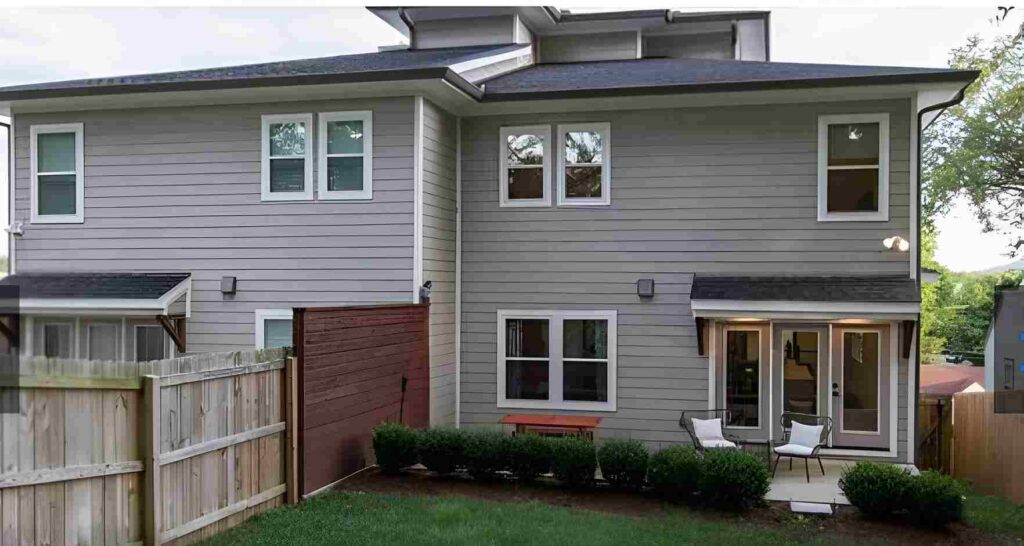 Wooden house with black roof and garden area