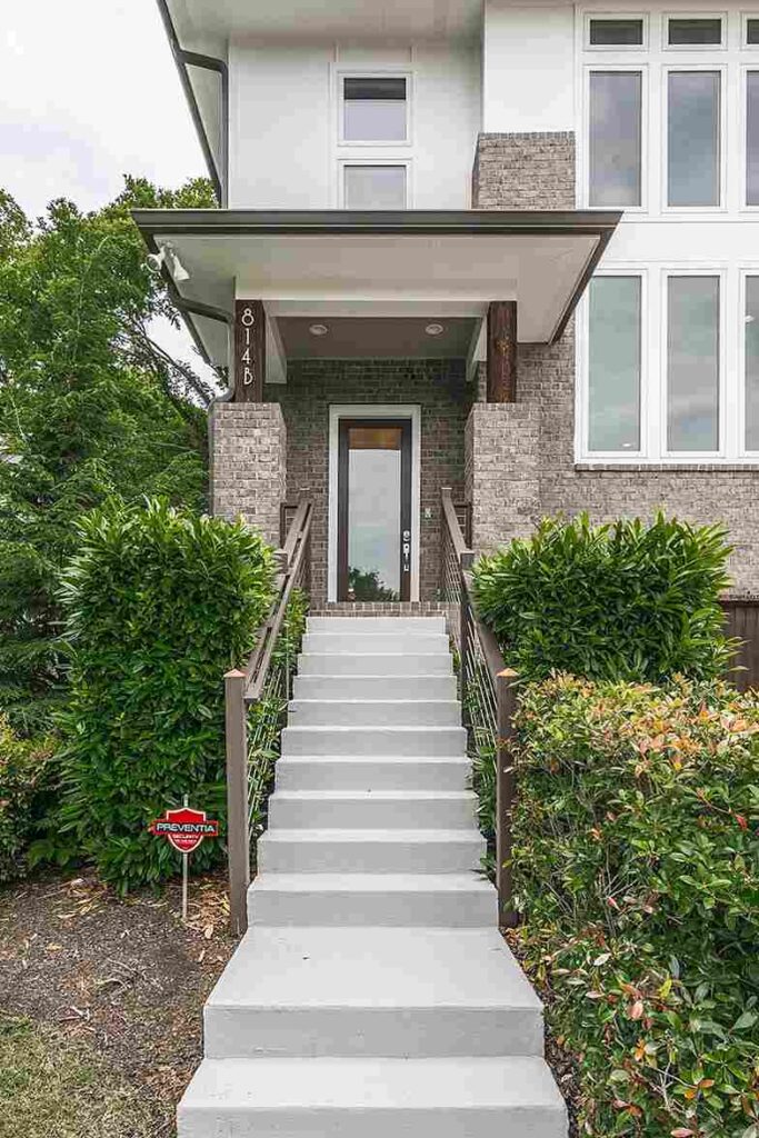 Stair with gray railing and half brick wall for the house exterior