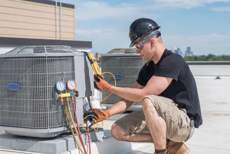 HVAC-technician-actively-working-on-an-outdoor-air-conditioning-unit-on-appears-to-be-a-rooftop