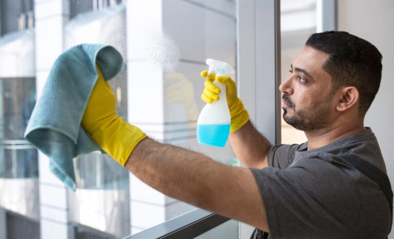a-man-is-cleaning-window-with-the-help-of-small-towel-and-cleanser-liquid