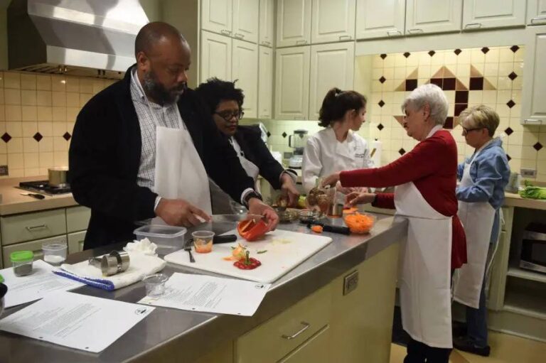 Designing Your New Kitchen for Family Wellness: How Smart Home Setup Supports Healthier Eating five-individual-visible-and-preparing-food-at-a-large-central-island-counter