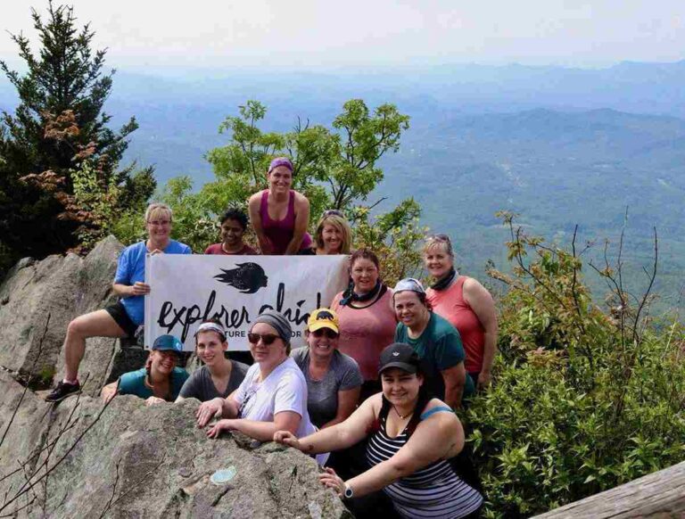 Stress-Free Family Getaway Planning: A Simple Smoky Mountains Checklist group-of-woman-posing-for-a-picture-and-background-features-a-moutainous-landscape-which-appears-to-be-smoky