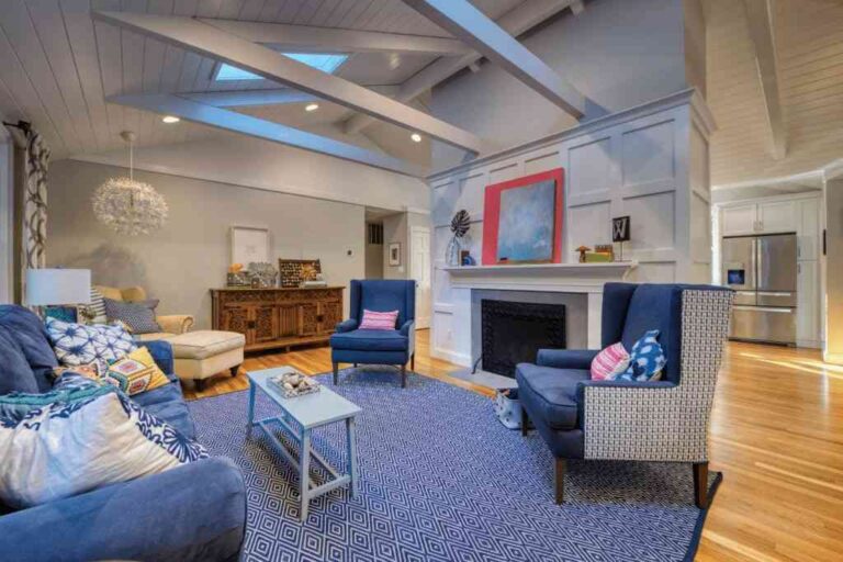 the-room-features-a-white-vaulted-ceiling-with-exposed-beams-and-skylights-which-add-natural-light-to-the-space