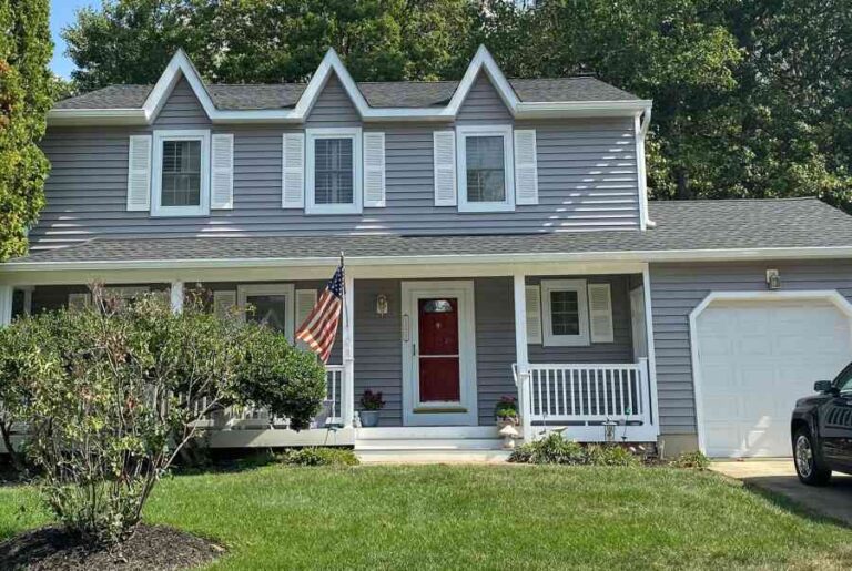 The Real Cost of Waiting Too Long to Replace Your Siding two-story-single-family-home-with-light-blue-or-grey-siding-and-white-trim