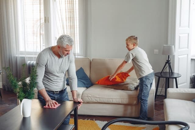 How to Stay Motivated for Deep Cleaning Projects older-man-and-boy-in-a-living-room-appearing-to-declutter-or-cleaning-together