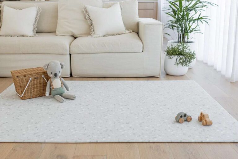 a-large-light-grey-padded-baby-play-mat-from-the-brand-luxe-at-play-designed-to-look-like-a-luxury-rug-while-providing-a-safe-cushioned-area-for-infants
