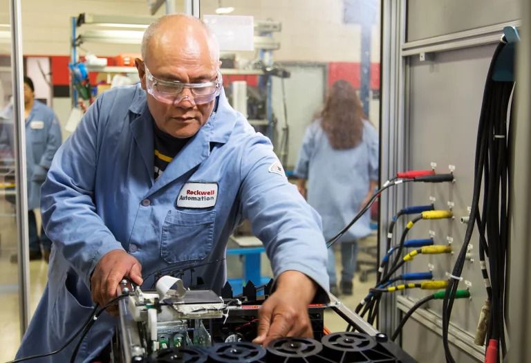 Maximizing Asset Efficiency through Strategic Material Selection a-technician-in-a-blue-lab-coat-and-safety-glasses-working-on-a-piece-of-industrial-equipment