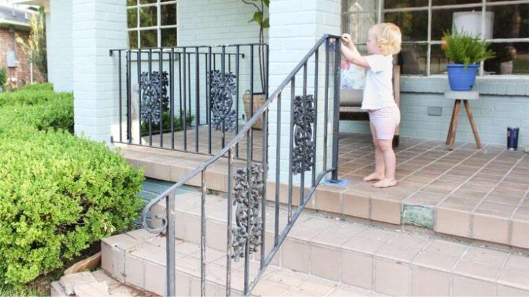 the-entrance-of-a-house-with-black-metal-railing-and-a-small-child-standing-near-the-stairs